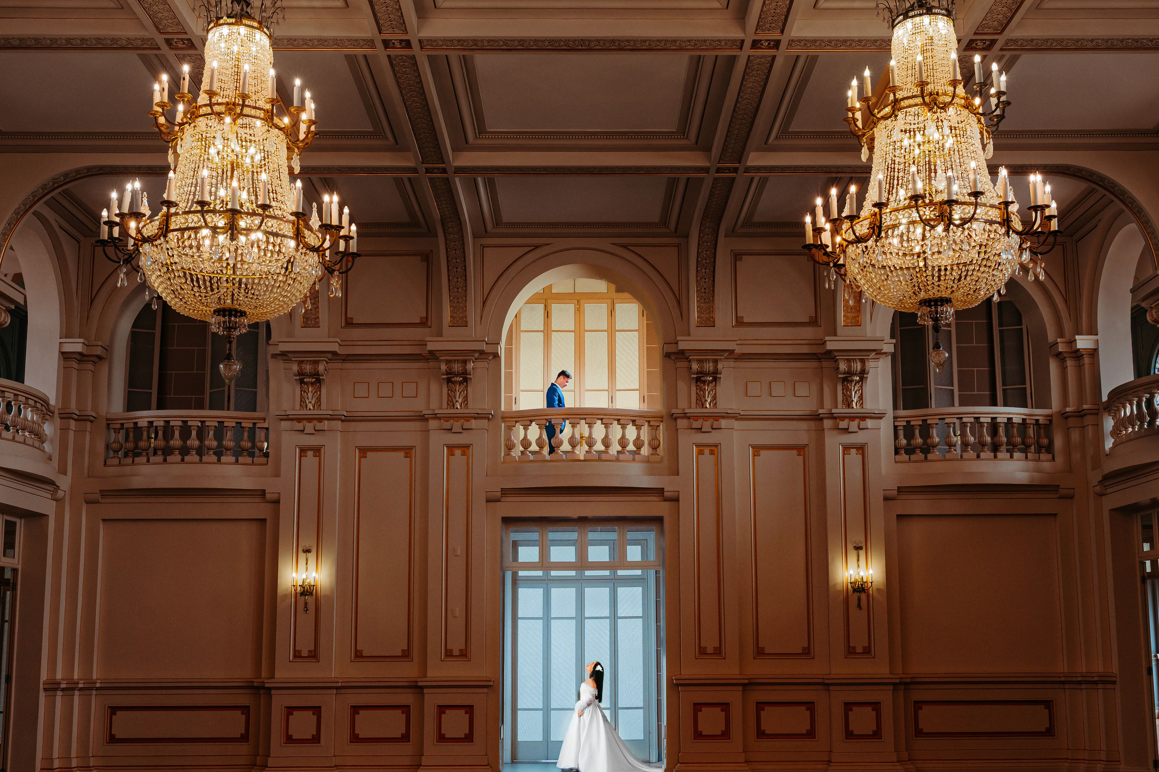 Noiva com cauda gigante na escada, noivo acima